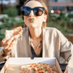 Frau genießt Pizza im Freien – Symbolbild für hormonelle Auswirkungen unserer Ernährung im Alltag